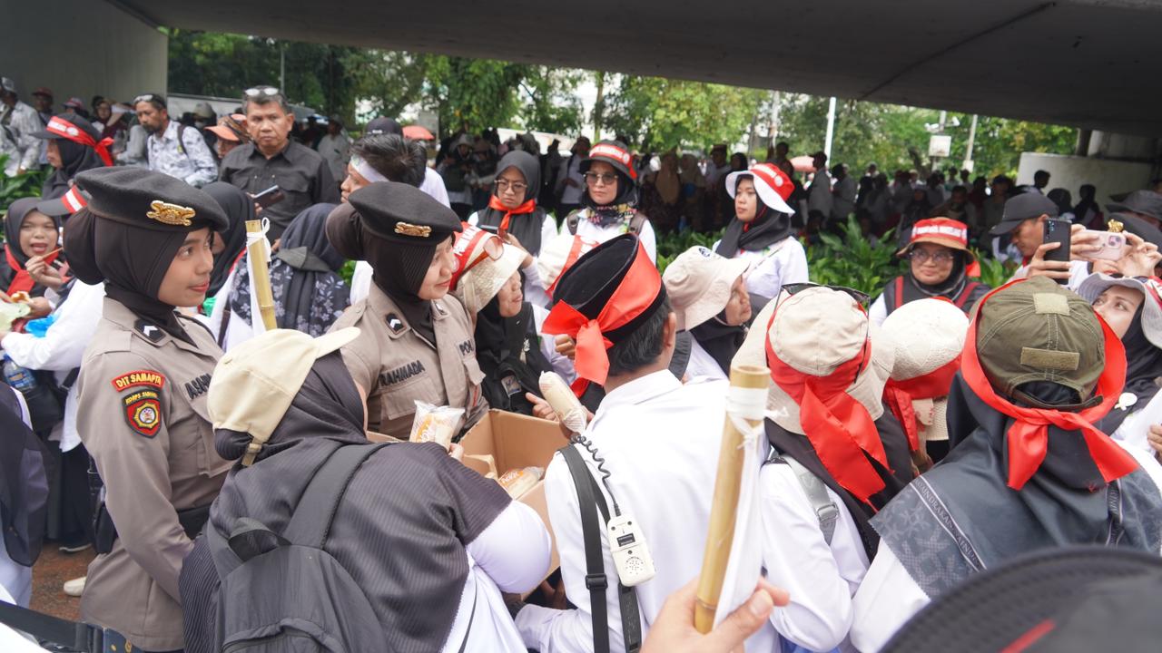 Polisi Bagikan Air Mineral dan Roti ke Massa Aksi Guru Honorer di DPR